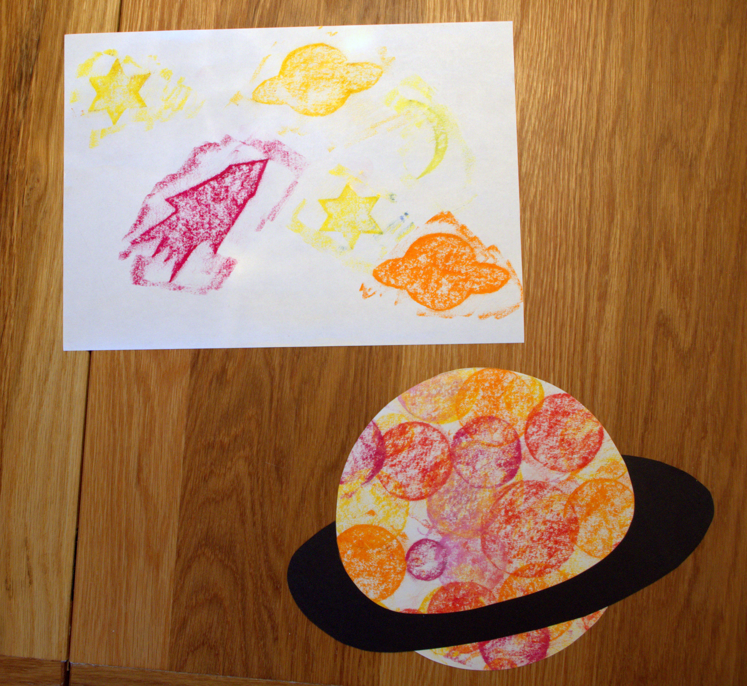 Space Rubbings - Space-themed pictures made by rubbing crayons over cardboard cut-out shapes.