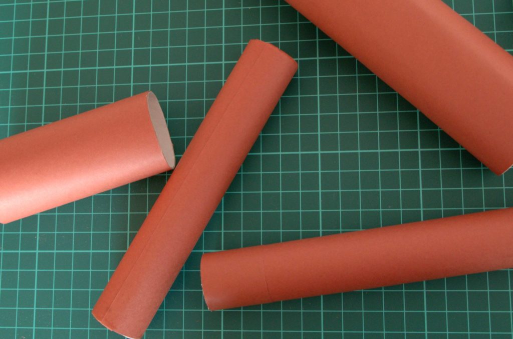 Cardboard tubes covered with brown paper.