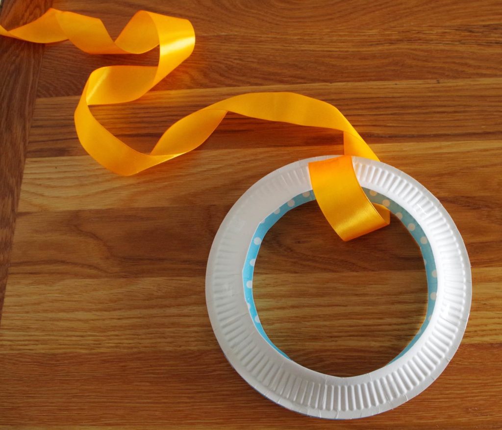 Length of coloured ribbon attached to a paper plate ring.