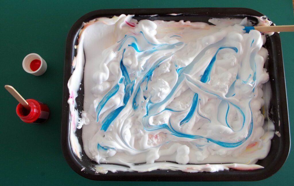 Swirl colour into the shaving foam to get the marbling effect.