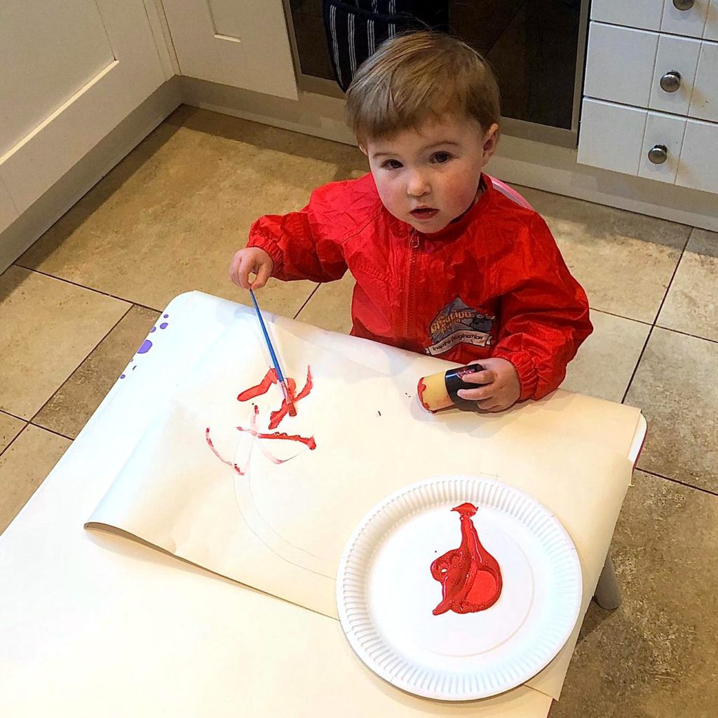 Toddler Crafts - Process Art: Painting with a paint brush on a large sheet of paper.